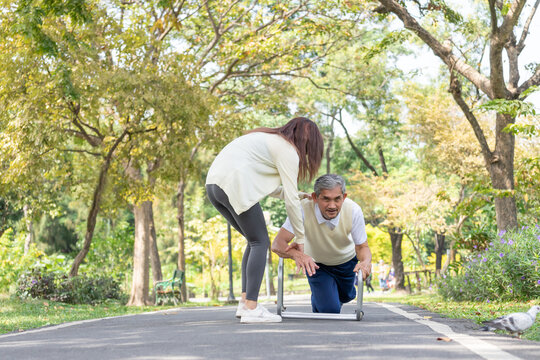 an elderly man fell down while walking with walker aid in the park,a daughter is helping him to get up