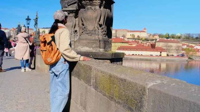 Strolling along the scenic riverside, a traveler admires the stunning views of Pragues architecture and vibrant atmosphere. This moment captures the essence of a perfect day in the city.