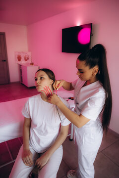 Cosmetologist applying kinesiology tape for facial lifting treatment