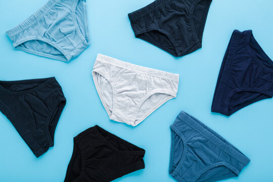 Colorful panties for little child boy on light blue table background. Pastel color. Clothes pattern. Closeup. Top down view.