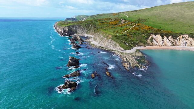 Aerial shot flying low over rocky coastline near Lulworth Cove, Dorset