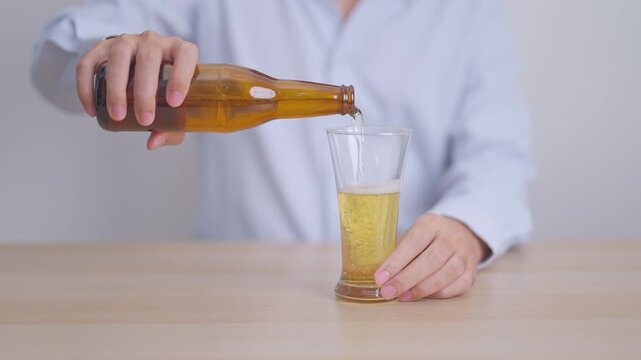 man pour Beer into a glass on table, suffering from alcohol addiction, alcoholism concept. depicting emotional distress, depression, substance abuse problem, unhealthy lifestyle and mental health