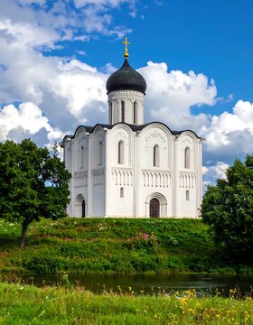 Church Of The Intercession On The Nerl Ancient White Stone Russian Orthodox Temple On A Green Grassy Hill Under A Bright Blue With White Clouds