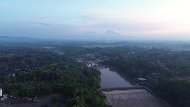 Misty Sunrise Aerial View of Progo River Bridge with Mount Merapi and Mount Merbabu in the Background, Yogyakarta, Indonesia