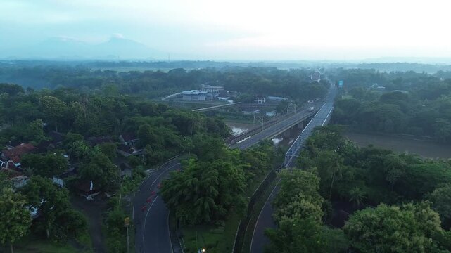 Misty Sunrise Aerial View of Progo River Bridge with Mount Merapi and Mount Merbabu in the Background, Yogyakarta, Indonesia