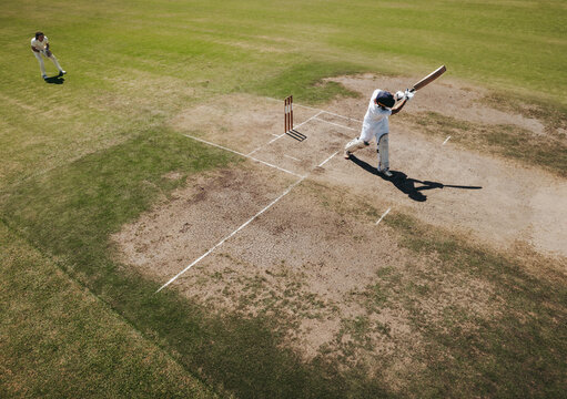 Batsman swinging the bat during a cricket match on the field