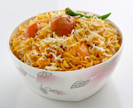 Delicious Spicy Chicken Biryani with aloo and green chili in a decorative bowl isolated on white background