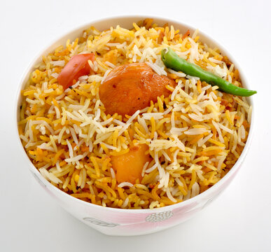 Delicious Spicy Chicken Biryani with aloo and green chili in a decorative bowl isolated on white background