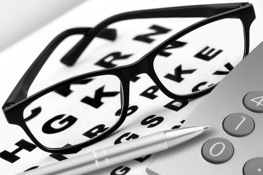 Brille und Rechner mit Sehtafel