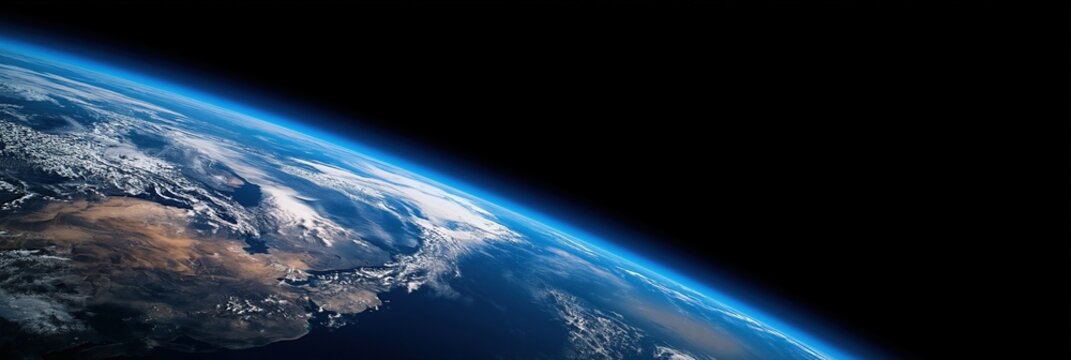 A stunning view of Earth"s curvature from space showing clouds, land, and the thin blue atmosphere against the blackness of space.