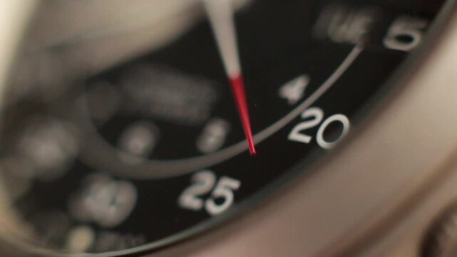 Macro close up of an automatic mechanical field watch with moving arms
