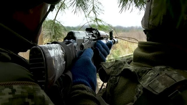 Soldiers in a dugout aiming from cover at a target during combat. Concept of defensive positions, military tactics, and battlefield engagement. Frontline conditions, teamwork, and readiness in active