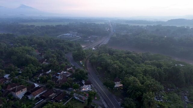 Misty Sunrise Aerial View of Progo River Bridge with Mount Merapi and Mount Merbabu in the Background, Yogyakarta, Indonesia