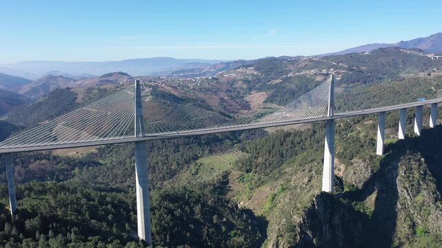 Drone view of picturesque spring landscape with mountains covered with green forests in Vila Real district in Portugal and high modern suspension viaduct with highway crossing Corgo River gorge 