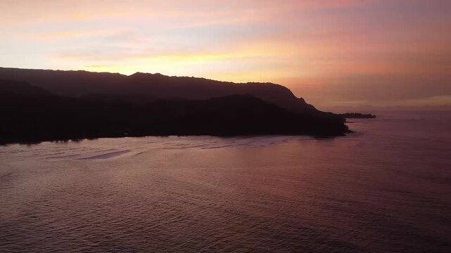 Aerial drone sunset over tropical bay with mountains and ocean Hawaii