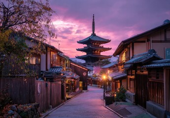 Naklejka premium A picturesque view of a traditional Japanese street lined with wooden buildings, leading towards a stunning pagoda bathed in the warm glow of a vibrant sunset.
