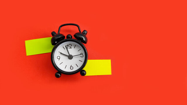 Alarm clock with extended sticky notes representing timeline, planning, and long-term scheduling.