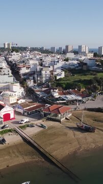 Vertical aerial orbit around Alvor village on a sunny summer day in Algarve, Portugal.