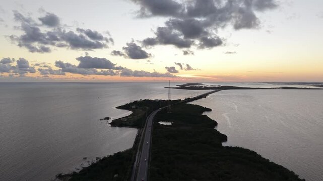 Cinematic aerial drone footage of the Seven Mile Bridge at sunset, showcasing the modern highway and historic bridge pillars in golden light.