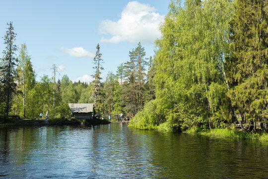 Landscape with a wooden hut on the bank of a forest river in Karelia, eco-trail, hiking