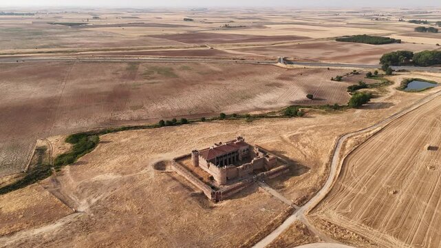 Aerial drone shot moving forward revealing abandoned castle in rural landscape
