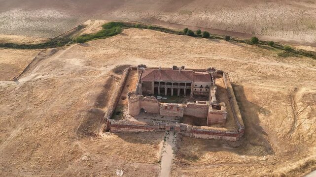 Drone flying backward moving away from abandoned castle in countryside