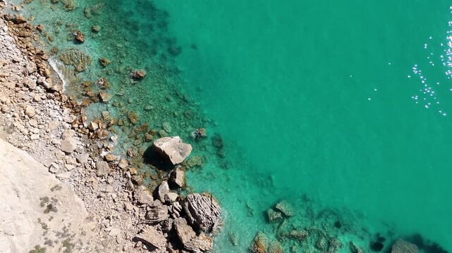 Cinematic slow drone shot pulling back top down over Mediterranean waves
