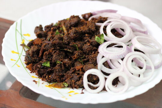 kerala style beef fry- spicy and aromatic dish . Tender beef chunks roasted with coconut oil, curry leaves and coconut slivers.