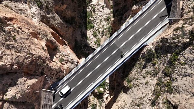 Top down drone shot moving backward over Mascarat Canyon bridges and traffic