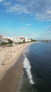 Aerial view of Arpoador beach and coastline with people, ocean and cityscape in Rio de Janeiro, Brazil