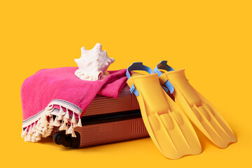 Suitcase, flippers, towel and seashell on color background © Pixel-Shot