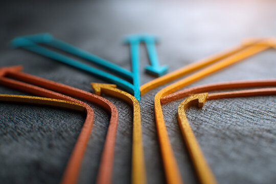 Colorful arrows converging and diverging on a textured surface representing choices directions and pathways