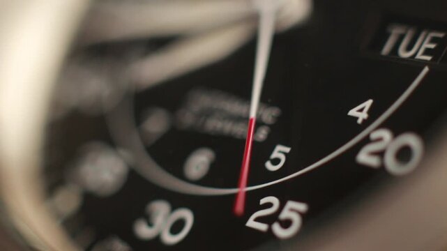 Macro close up of an automatic mechanical field watch with moving arms
