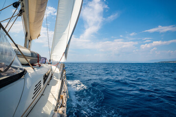 Fototapeta premium Side of a sailing yacht cutting through the sea with full sails near Croatia. Motion, freedom, sailing lifestyle and adventure on the open water.
