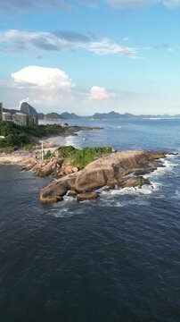Aerial view of Arpoador rock with people and Atlantic Ocean coastline in Rio de Janeiro, Brazil