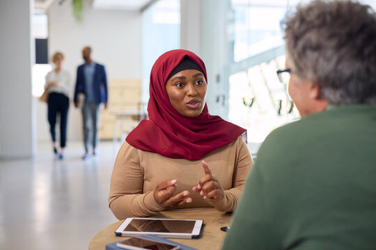 Businesswoman in hijab making financial consultation with client