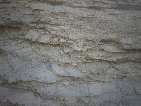 Texture di roccia sedimentaria stratificata con livelli irregolari, tonalit&agrave; marroni con superficie ruvida illuminata dal sole, ideale per materiali PBR e rendering 3D realistici