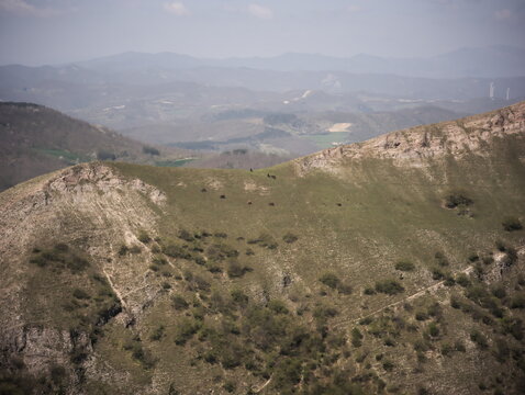 Paesaggio montano con montagne ondulate, vegetazione sparsa e cielo limpido, una scena naturale ampia e luminosa ideale per contenuti dedicati a natura, viaggio e outdoor