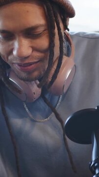 Vertical video: Recording starting, host reading tablet and talking into mic at window, copy space