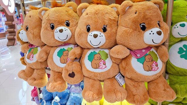 Group of cute brown Care Bears plush toys with Forest Friend Bear belly badge on display shelf on May 3, 2026 in Bangkok, Thailand.