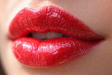 Obraz premium Close-up of glossy red lips with shimmer and shine