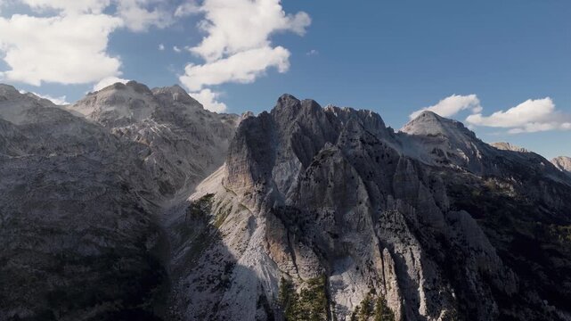 Aerial view of majestic mountain peaks and deep valleys, where light and shadow dance across the rugged terrain, creating a stunning natural landscape, Teth, Shkoder County, Albania.
