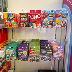 Fototapeta premium Assorted UNO card game decks on display at a retail store shelf featuring various themed editions and popular family card game packaging on April 19, 2026 in Bangkok, Thailand.