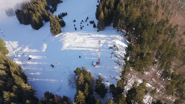 Aerial View of Transmitter Tower and Ski Slope in Winter Forest