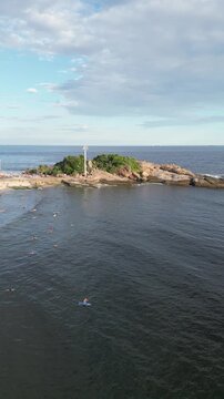 Aerial view of Arpoador rock with people and Atlantic Ocean coastline in Rio de Janeiro, Brazil