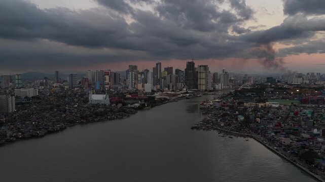 Aerial view of manila cityscape with river under stormy skies