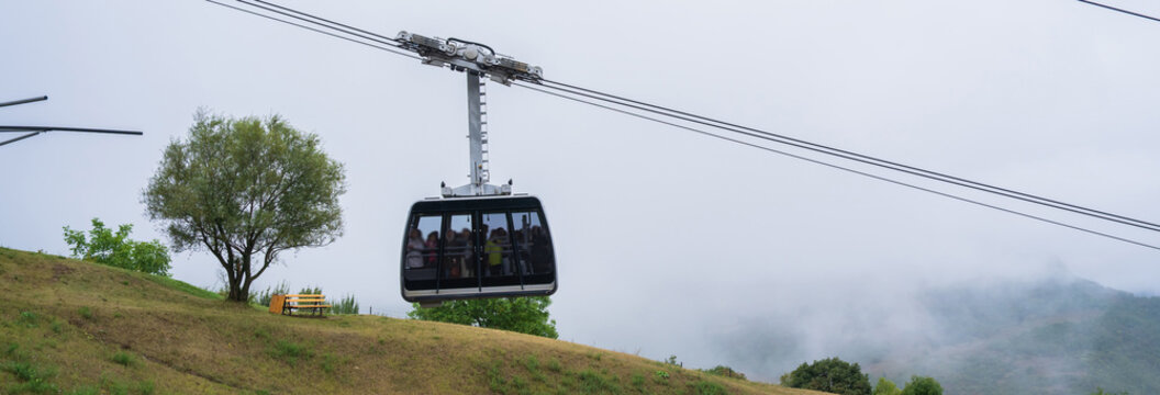 Ropeway cabin gliding above mountainous terrain, offering scenic aerial views, adventure tourism, and a thrilling perspective of rugged natural landscapes.