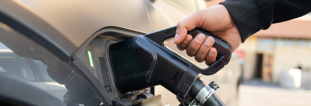 Electric vehicle connected to a charging station, symbolizing sustainable transportation, clean energy innovation, and the future of eco-friendly mobility.