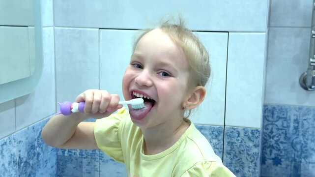 happy little girl brushing teeth and tongue