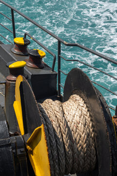 A heavy-duty marine winch with a thick rope is mounted on a ship deck, with the open sea in the background, symbolizing maritime work, transport, and nautical operations.